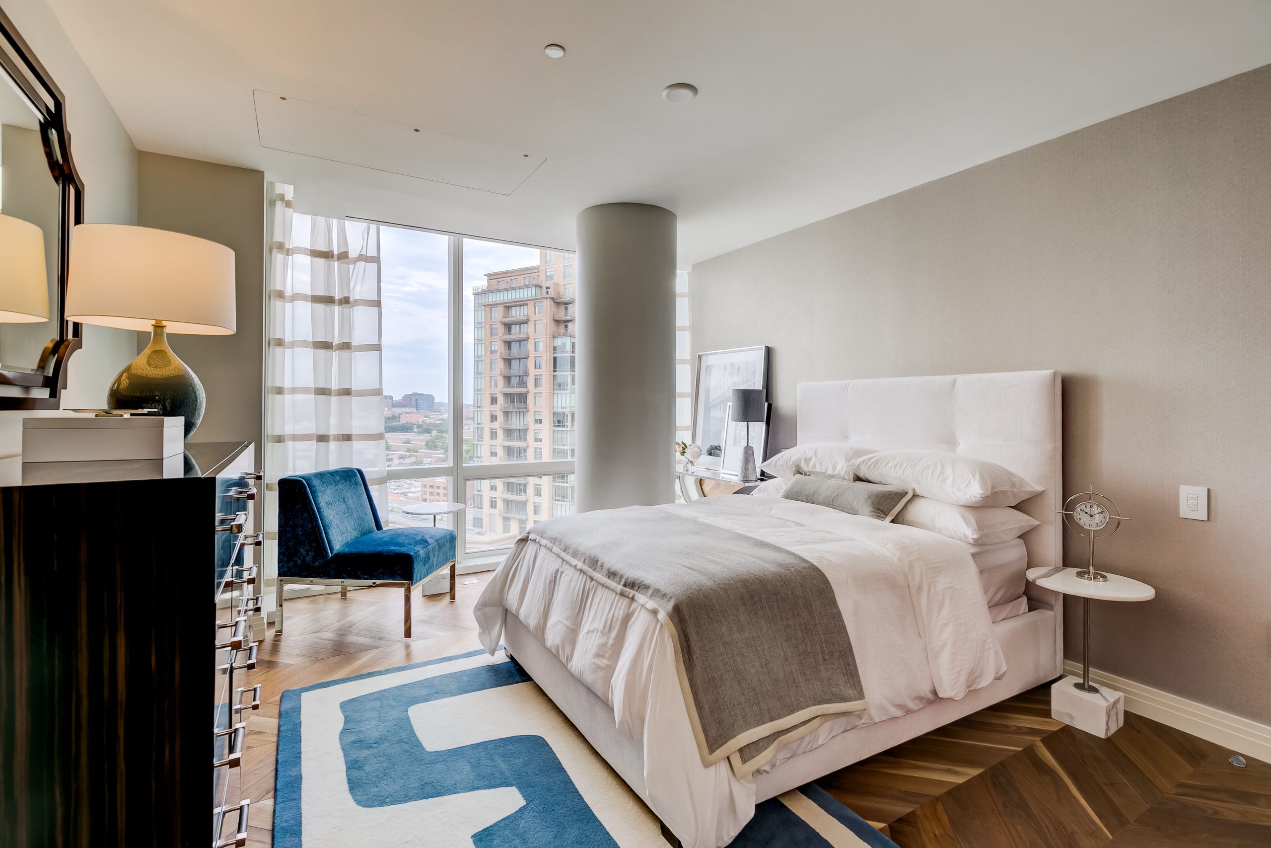 Guest bedroom with a blue geometric rug and upholstered bed