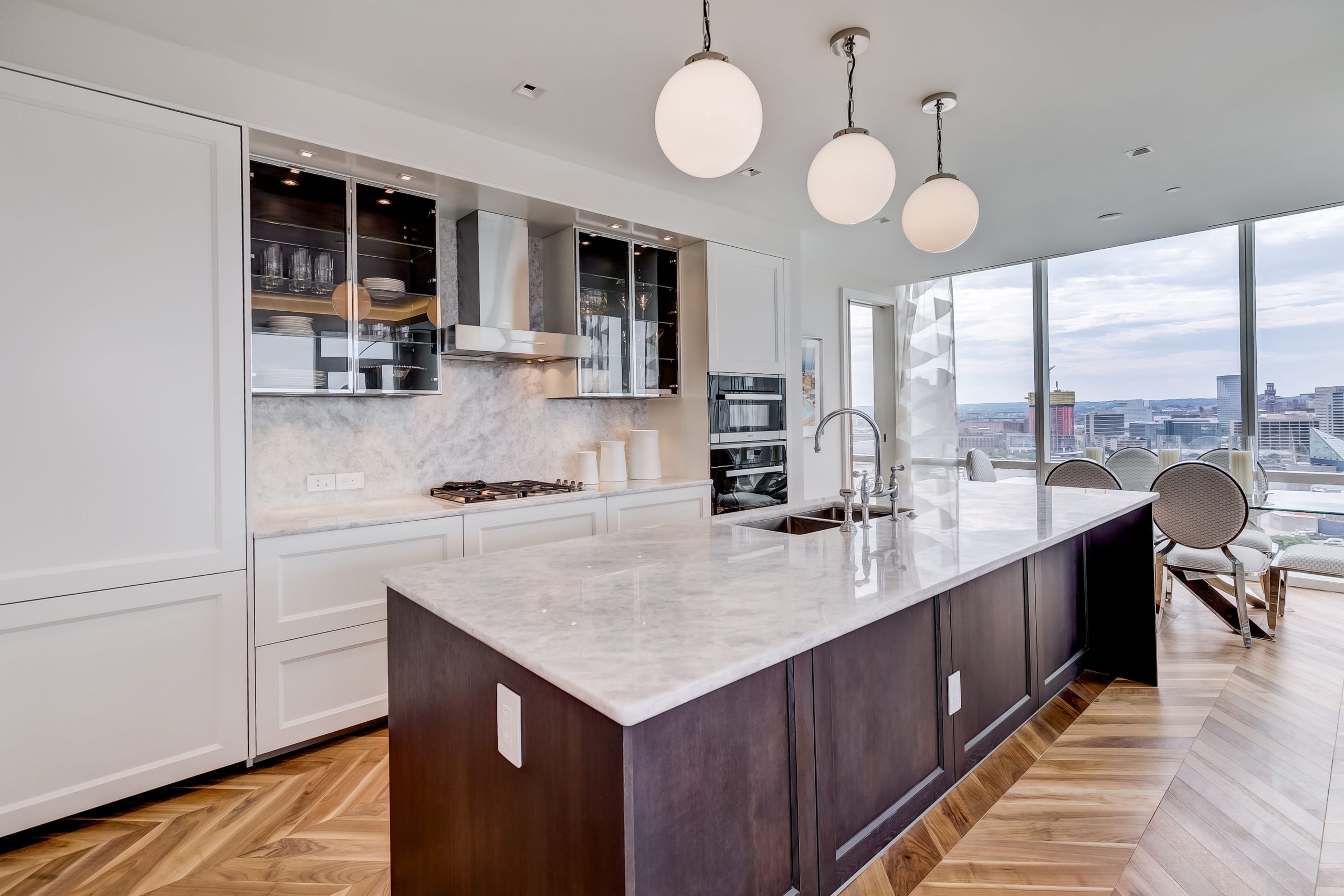 Kitchen island with marble countertop and globe pendant lights