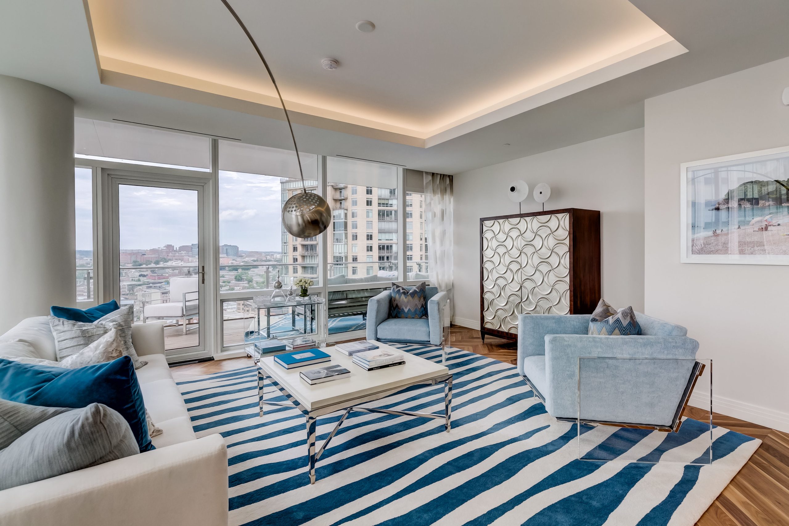 Living room facing the windows with an arched floor lamp