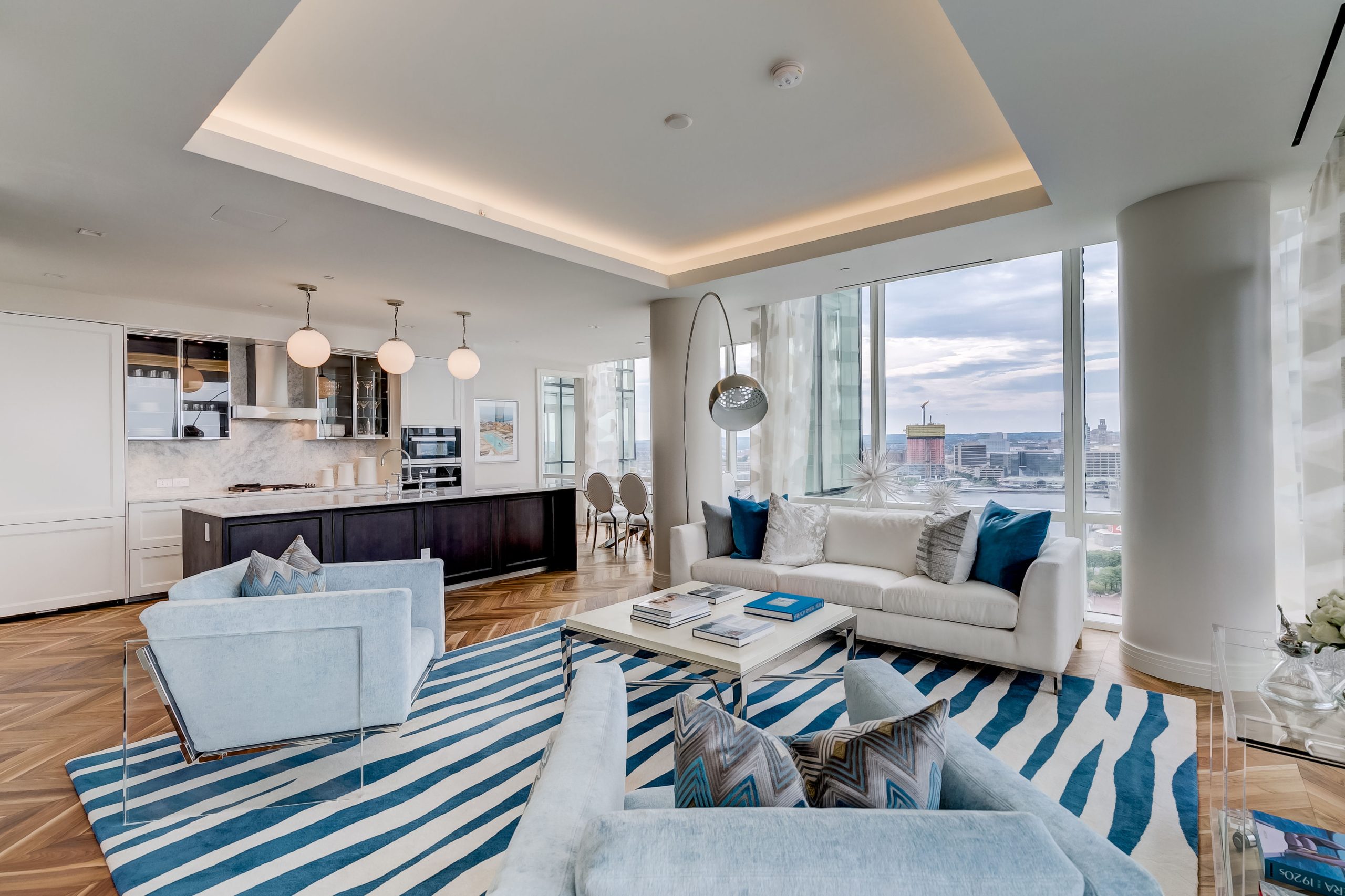 Living room with pale blue chairs and an ocean-inspired custom rug