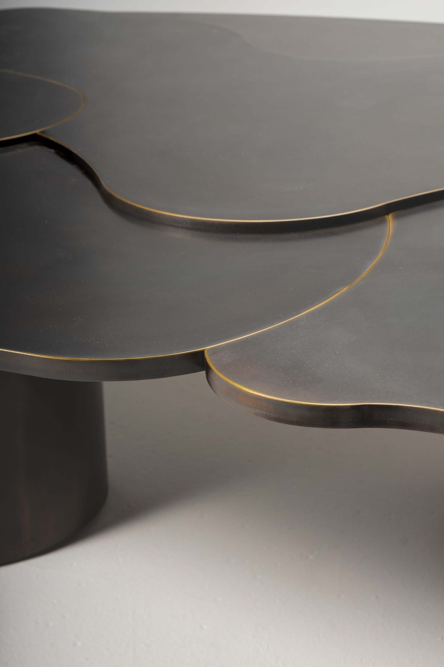 A detail of the overlapping tabletop layers and burnished edges.