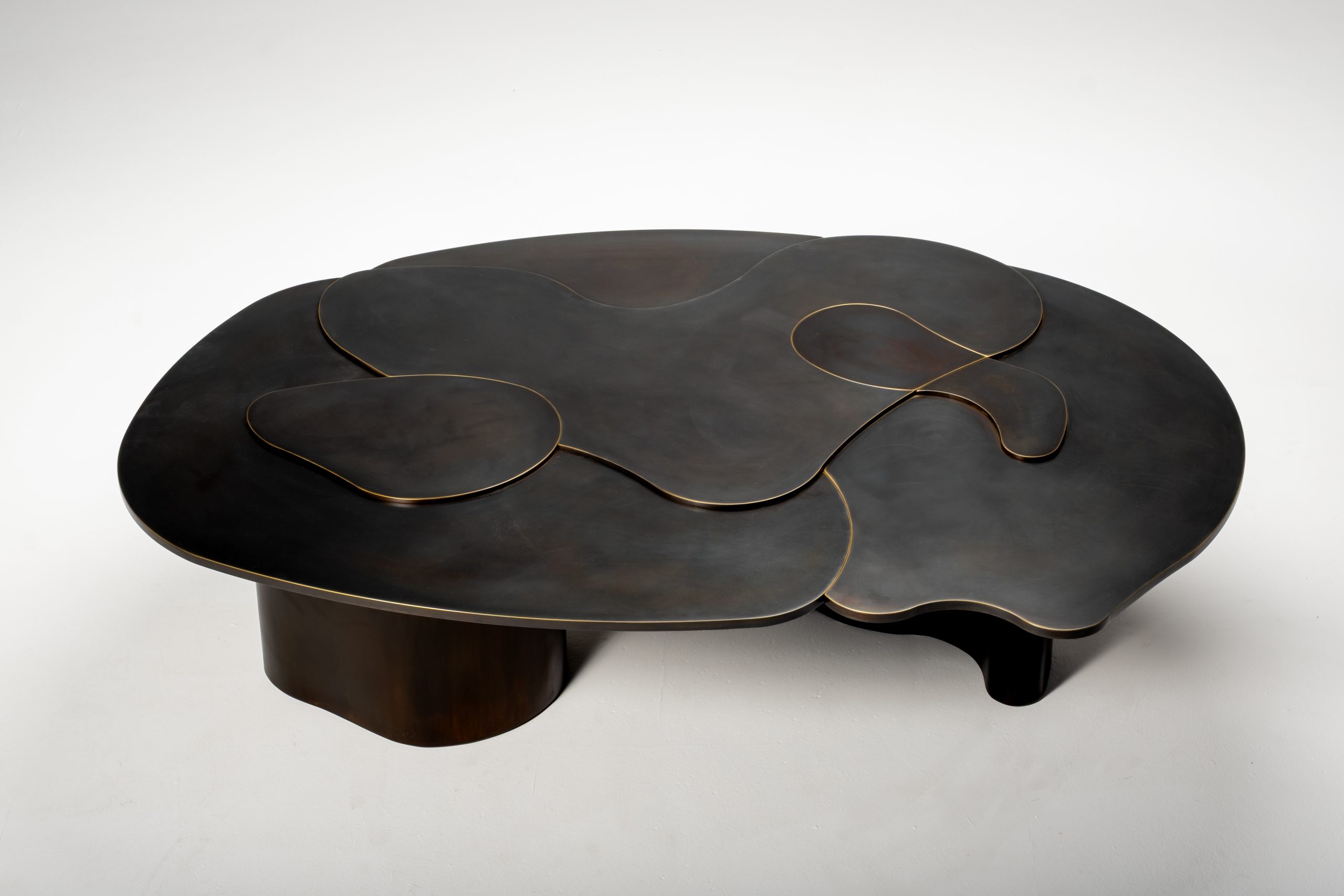 The complete Terralis coffee table, with layered brass surfaces and a dark patina.